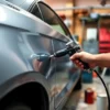 A person painting their car with a spray gun in a home garage, focusing on the car's side panel being refreshed with new paint, tools and paint cans nearby, realistic lighting, detailed textures of metal and paint, no text or signs visible