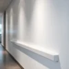 A modern interior wall with protective bumpers installed along the lower section, showing different types such as rubber, PVC, and metal profiles, neatly mounted on a clean white wall in a commercial or residential setting, with subtle shadows and realistic lighting to highlight texture and material details